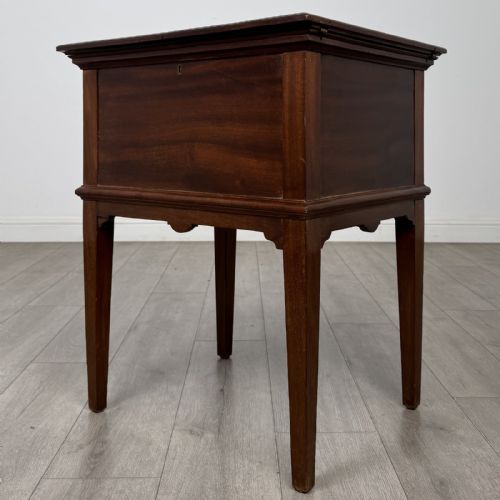 fig 3. A 19th-century mahogany fold-out cabinet standing on four square tapered legs with a brass keyhole escutcheon on the front casing.