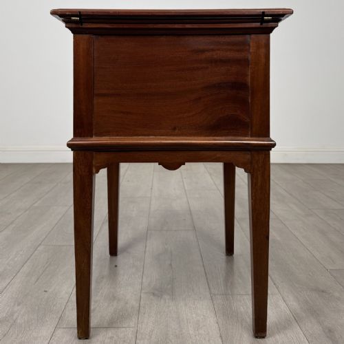 fig 4. A 19th-century mahogany fold-out cabinet standing on four square tapered legs with a brass keyhole escutcheon on the front casing.