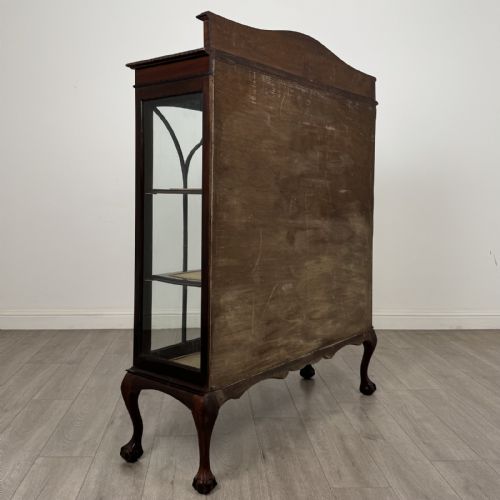fig 4. An Edwardian dark mahogany display cabinet with twin astragal glazed doors, fabric-lined interior shelves, and cabriole legs with carved claw and ball feet.