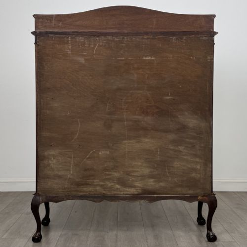 fig 5. An Edwardian dark mahogany display cabinet with twin astragal glazed doors, fabric-lined interior shelves, and cabriole legs with carved claw and ball feet.