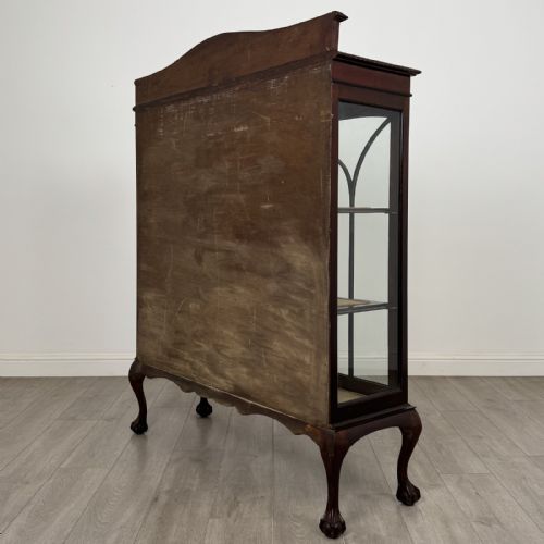 fig 6. An Edwardian dark mahogany display cabinet with twin astragal glazed doors, fabric-lined interior shelves, and cabriole legs with carved claw and ball feet.