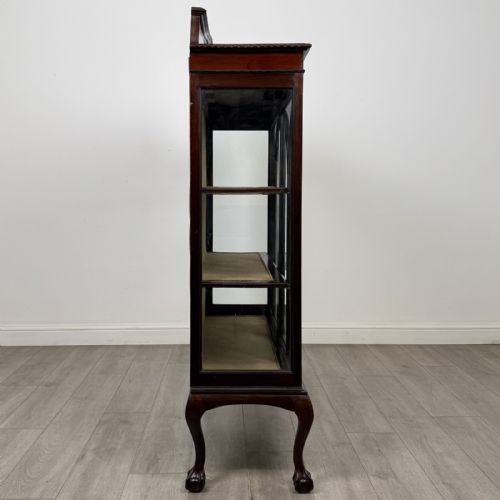 fig 7. An Edwardian dark mahogany display cabinet with twin astragal glazed doors, fabric-lined interior shelves, and cabriole legs with carved claw and ball feet.