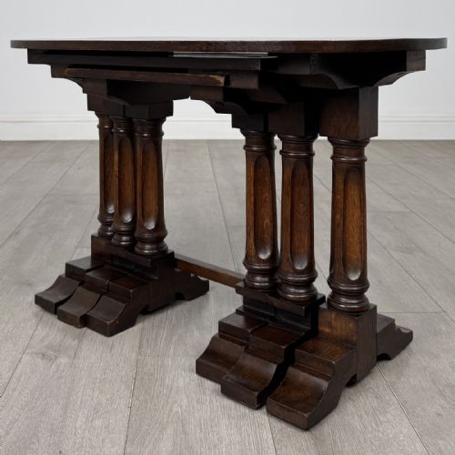 fig 2. A set of three nesting dark oak occasional tables featuring turned baluster legs and trestle feet.