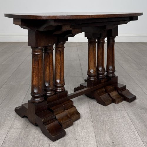 fig 6. A set of three nesting dark oak occasional tables featuring turned baluster legs and trestle feet.