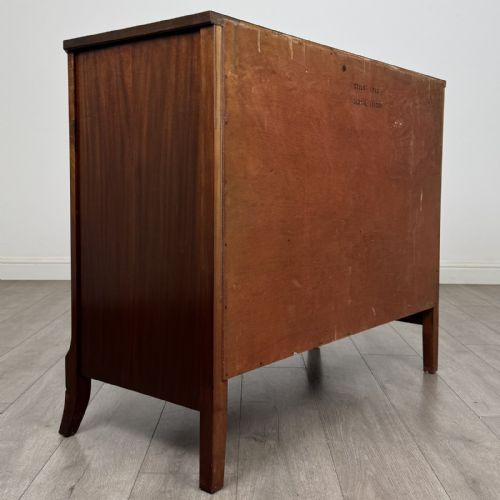 fig 3. A dark mahogany bow-fronted chest of drawers featuring brass oval ring handles, reeded side columns, and curved legs.