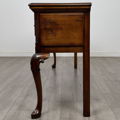 fig 2. A Queen Anne style elm dresser base featuring three drawers with brass handles, a shaped apron, and cabriole legs ending in pad feet.