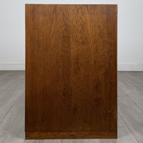 fig 7. A mid-century modern Danish oak cupboard featuring two flush panel doors and solid side supports.