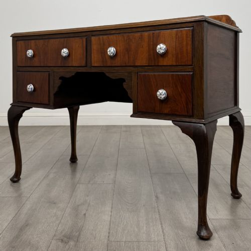 fig 1. An Edwardian walnut writing table featuring four drawers with blue and white patterned ceramic knobs, raised on cabriole legs.