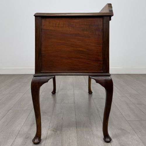fig 2. An Edwardian walnut writing table featuring four drawers with blue and white patterned ceramic knobs, raised on cabriole legs.