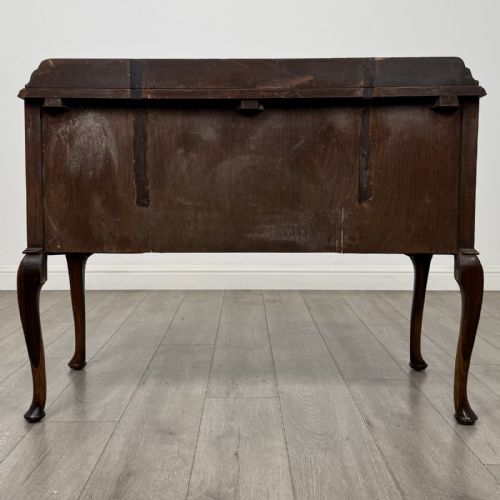 fig 4. An Edwardian walnut writing table featuring four drawers with blue and white patterned ceramic knobs, raised on cabriole legs.