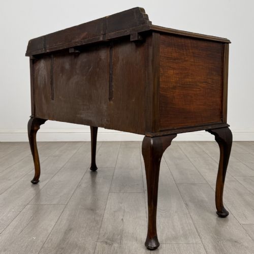 fig 5. An Edwardian walnut writing table featuring four drawers with blue and white patterned ceramic knobs, raised on cabriole legs.