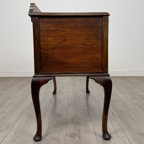 fig 6. An Edwardian walnut writing table featuring four drawers with blue and white patterned ceramic knobs, raised on cabriole legs.