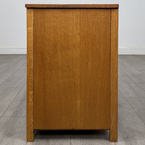 fig 2. A golden oak chest of drawers featuring three horizontal drawers with turned wooden knob handles resting on a shaped apron base.