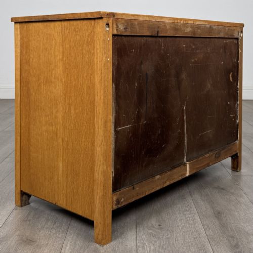 fig 3. A golden oak chest of drawers featuring three horizontal drawers with turned wooden knob handles resting on a shaped apron base.