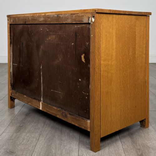 fig 5. A golden oak chest of drawers featuring three horizontal drawers with turned wooden knob handles resting on a shaped apron base.