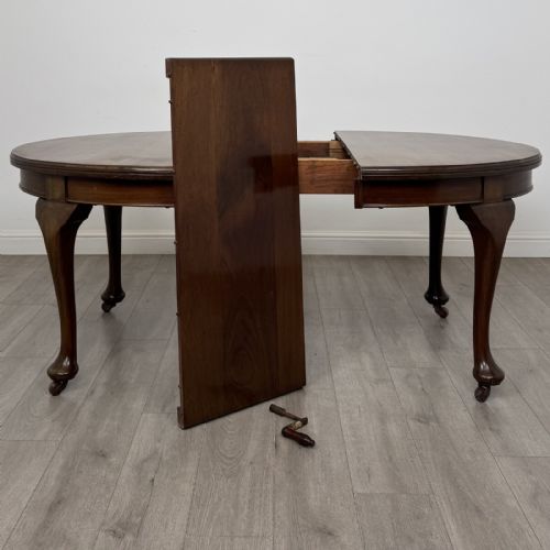 fig 2. An antique Edwardian oval mahogany extending dining table featuring cabriole legs on castors with a removable centre leaf.