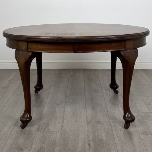 fig 4. An antique Edwardian oval mahogany extending dining table featuring cabriole legs on castors with a removable centre leaf.
