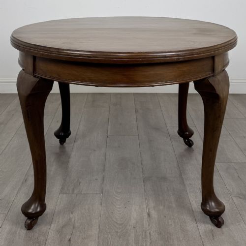 fig 5. An antique Edwardian oval mahogany extending dining table featuring cabriole legs on castors with a removable centre leaf.