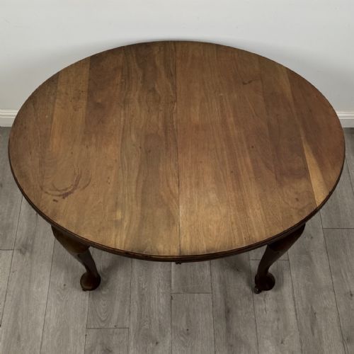 fig 6. An antique Edwardian oval mahogany extending dining table featuring cabriole legs on castors with a removable centre leaf.