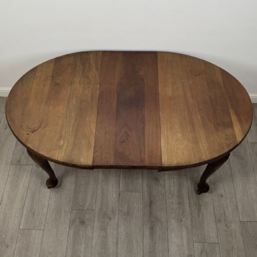 fig 7. An antique Edwardian oval mahogany extending dining table featuring cabriole legs on castors with a removable centre leaf.