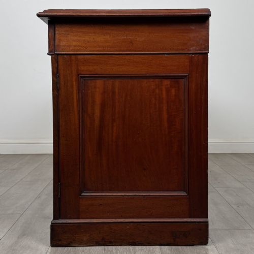 fig 3. A Victorian mahogany twin pedestal desk featuring a breakfront top, three upper frieze drawers, and two panelled cupboard doors on a plinth base.