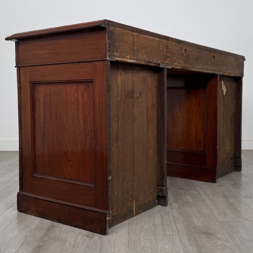 fig 4. A Victorian mahogany twin pedestal desk featuring a breakfront top, three upper frieze drawers, and two panelled cupboard doors on a plinth base.