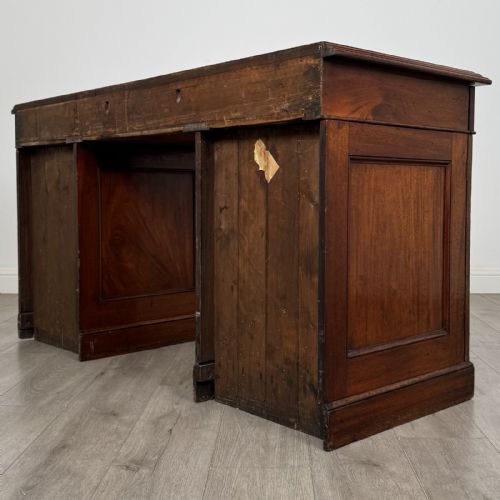 fig 6. A Victorian mahogany twin pedestal desk featuring a breakfront top, three upper frieze drawers, and two panelled cupboard doors on a plinth base.