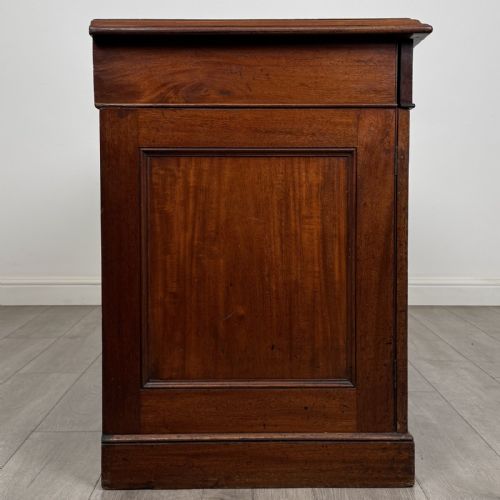fig 7. A Victorian mahogany twin pedestal desk featuring a breakfront top, three upper frieze drawers, and two panelled cupboard doors on a plinth base.