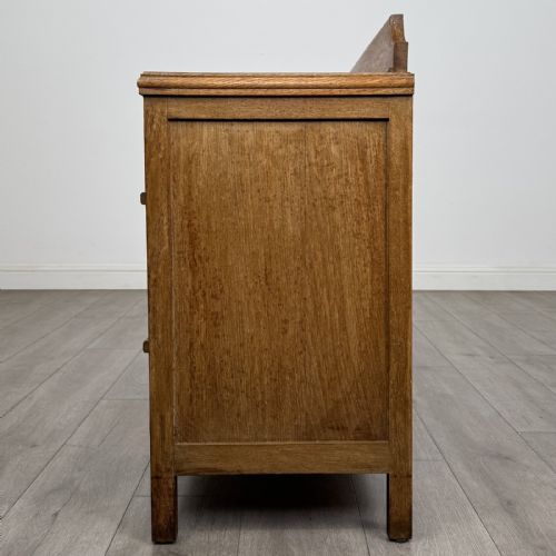 fig 2. An antique golden oak chest of drawers featuring two full-width drawers with matching rectangular wooden handles and a low raised gallery upstand.