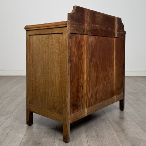 fig 3. An antique golden oak chest of drawers featuring two full-width drawers with matching rectangular wooden handles and a low raised gallery upstand.