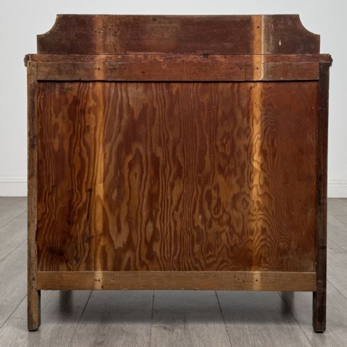 fig 4. An antique golden oak chest of drawers featuring two full-width drawers with matching rectangular wooden handles and a low raised gallery upstand.