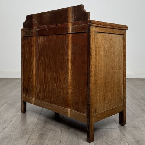 fig 5. An antique golden oak chest of drawers featuring two full-width drawers with matching rectangular wooden handles and a low raised gallery upstand.