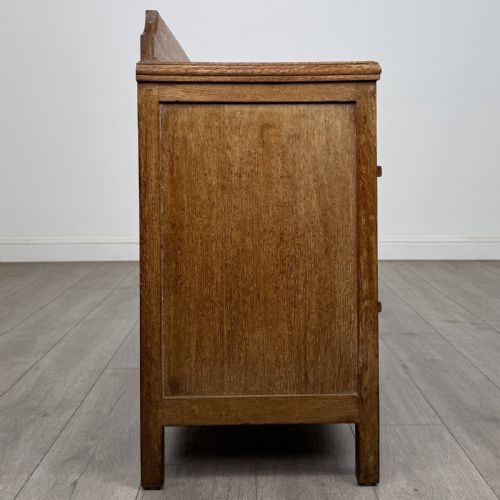 fig 6. An antique golden oak chest of drawers featuring two full-width drawers with matching rectangular wooden handles and a low raised gallery upstand.