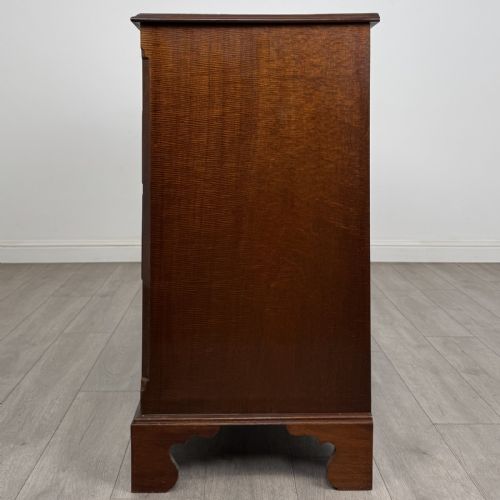 fig 2. A Georgian style mahogany chest of drawers featuring a two-over-three drawer arrangement, brass ring handles, and bracket feet.