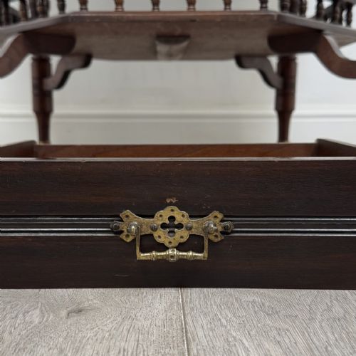 fig 8. An antique dark mahogany octagonal centre table featuring a drawer with a brass drop handle, ring-turned legs on brass castors, and an octagonal lower shelf with a spindle gallery.