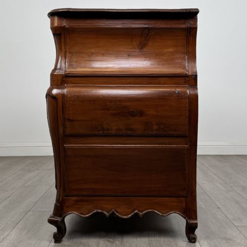 fig 2. An 18th-century French Louis XV bombe commode in warm brown cherrywood featuring ornate brass handles and cabriole legs.