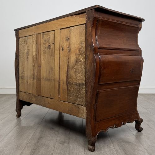 fig 5. An 18th-century French Louis XV bombe commode in warm brown cherrywood featuring ornate brass handles and cabriole legs.