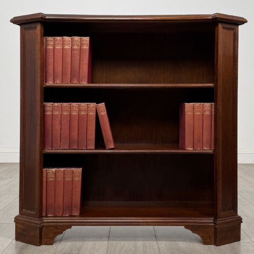 fig 1. An antique mahogany low open bookcase featuring canted corner posts, three tiers of open shelving, and a shaped bracket foot base.