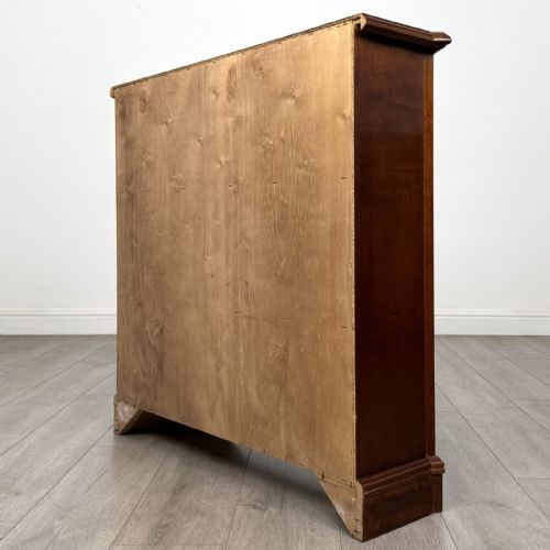 fig 6. An antique mahogany low open bookcase featuring canted corner posts, three tiers of open shelving, and a shaped bracket foot base.