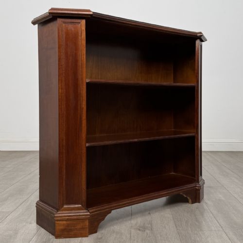 fig 8. An antique mahogany low open bookcase featuring canted corner posts, three tiers of open shelving, and a shaped bracket foot base.