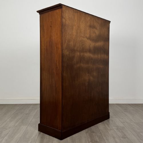 fig 4. A Georgian style dark mahogany display cabinet featuring two glazed doors with geometric astragal glazing bars and interior green silk lining.