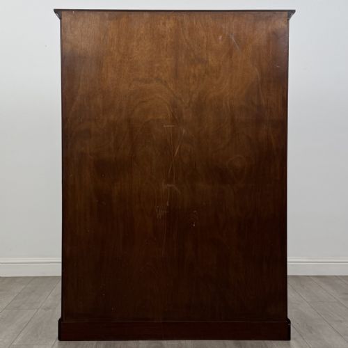 fig 5. A Georgian style dark mahogany display cabinet featuring two glazed doors with geometric astragal glazing bars and interior green silk lining.