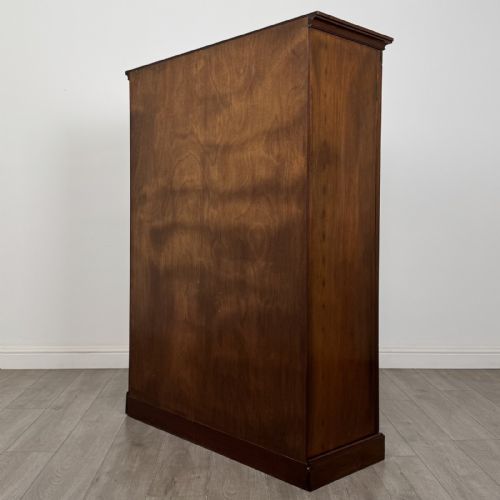 fig 6. A Georgian style dark mahogany display cabinet featuring two glazed doors with geometric astragal glazing bars and interior green silk lining.