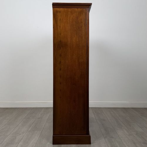 fig 7. A Georgian style dark mahogany display cabinet featuring two glazed doors with geometric astragal glazing bars and interior green silk lining.