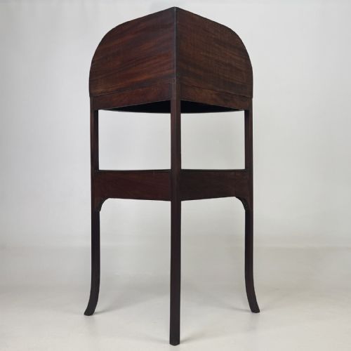 fig 2. A Georgian style mahogany corner stand featuring a curved raised gallery, inlaid drawer, white handles, and slender splayed legs.