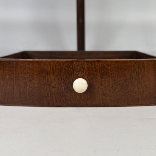 fig 6. A Georgian style mahogany corner stand featuring a curved raised gallery, inlaid drawer, white handles, and slender splayed legs.