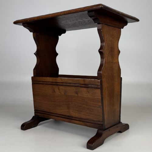 fig 5. A dark brown oak side table featuring a flat rectangular top supported by shaped vertical legs and a lower integrated magazine compartment.