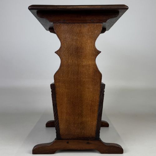 fig 6. A dark brown oak side table featuring a flat rectangular top supported by shaped vertical legs and a lower integrated magazine compartment.
