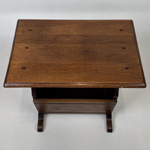 fig 8. A dark brown oak side table featuring a flat rectangular top supported by shaped vertical legs and a lower integrated magazine compartment.