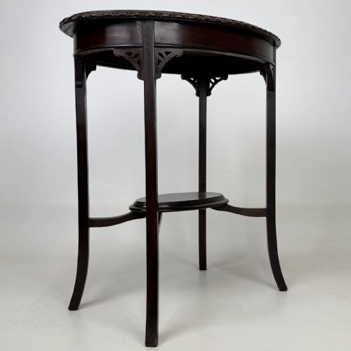 fig 3. An Edwardian oval mahogany side table featuring a carved gadrooned top edge, pierced corner brackets, slender tapered legs, and a lower oval shelf.